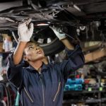 Black,Mechanic,Woman,Fixing,Underneath,Car,In,Auto,Repair,Shop,